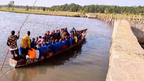 School pupils crossing the river by canoe to reach their school