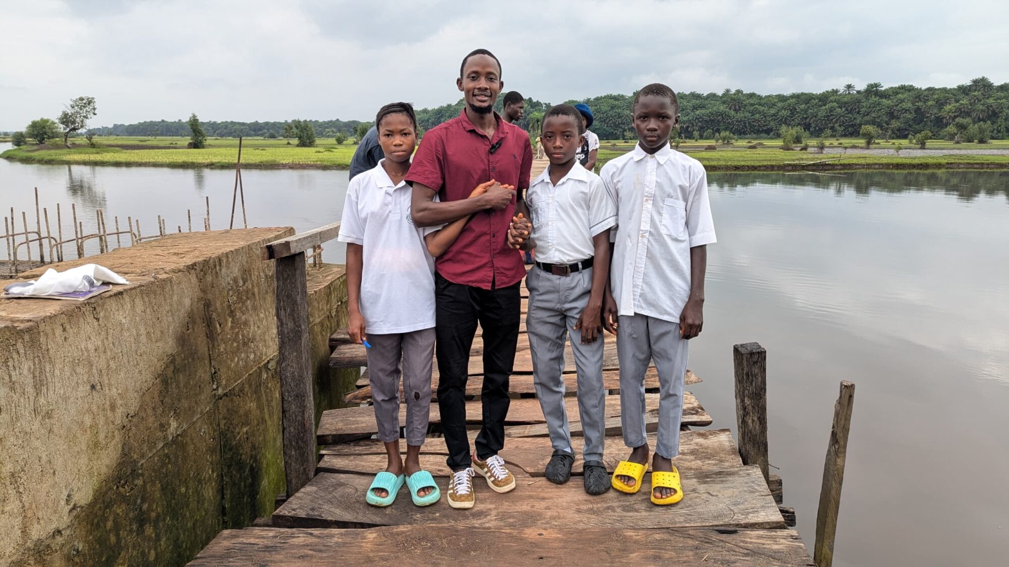 Ibrahim standing on the bridge with three school pupils