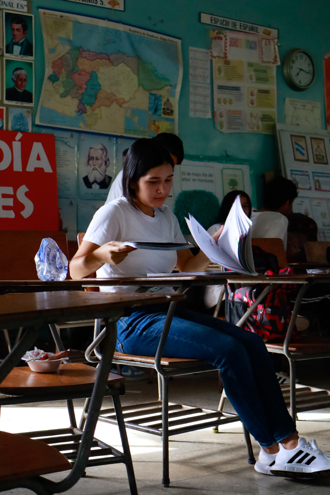 13-year-old “Ana” studies her worn notebook, preparing for the afternoon session