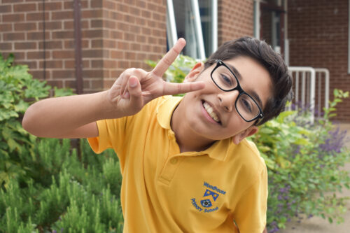 Umur, 9, posing for a photo after a day at school