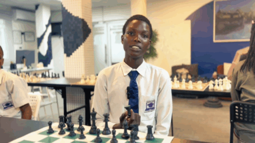 A child from Makoko holding a chess piece