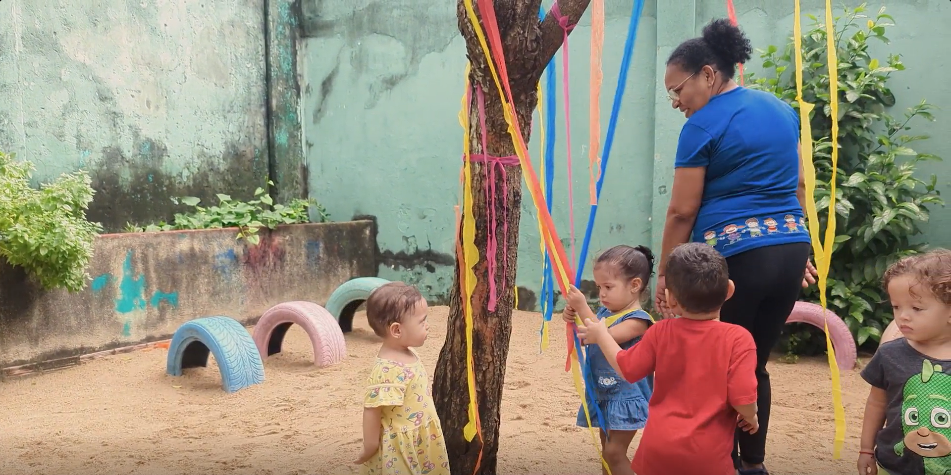 Still taken from João's video of children and an educator playing around a tree