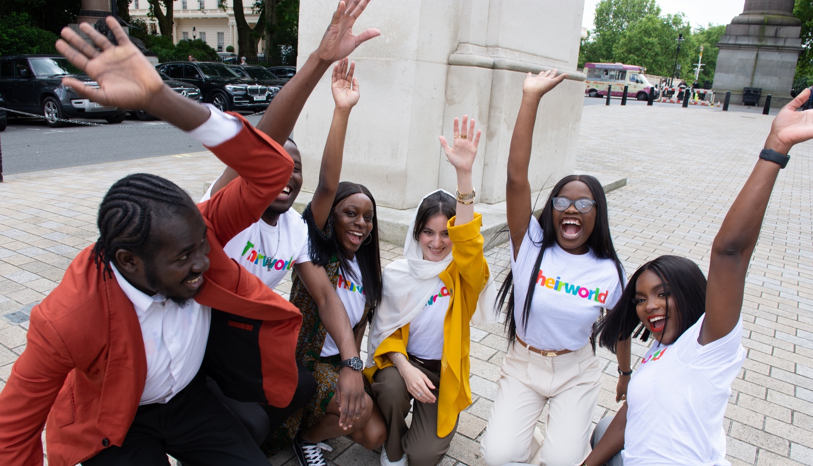 Photo of Global Youth Ambassadors raising their hands